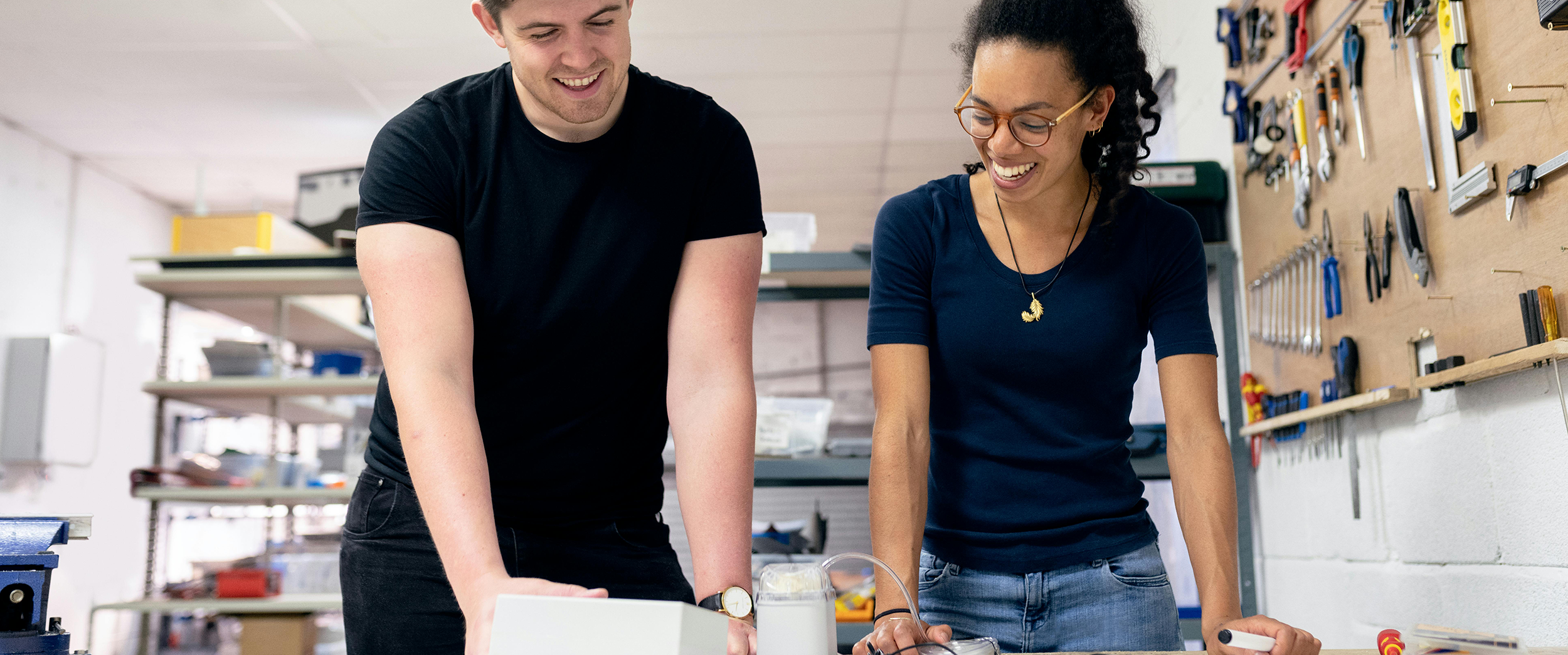 Man and woman leaning on a table laughing